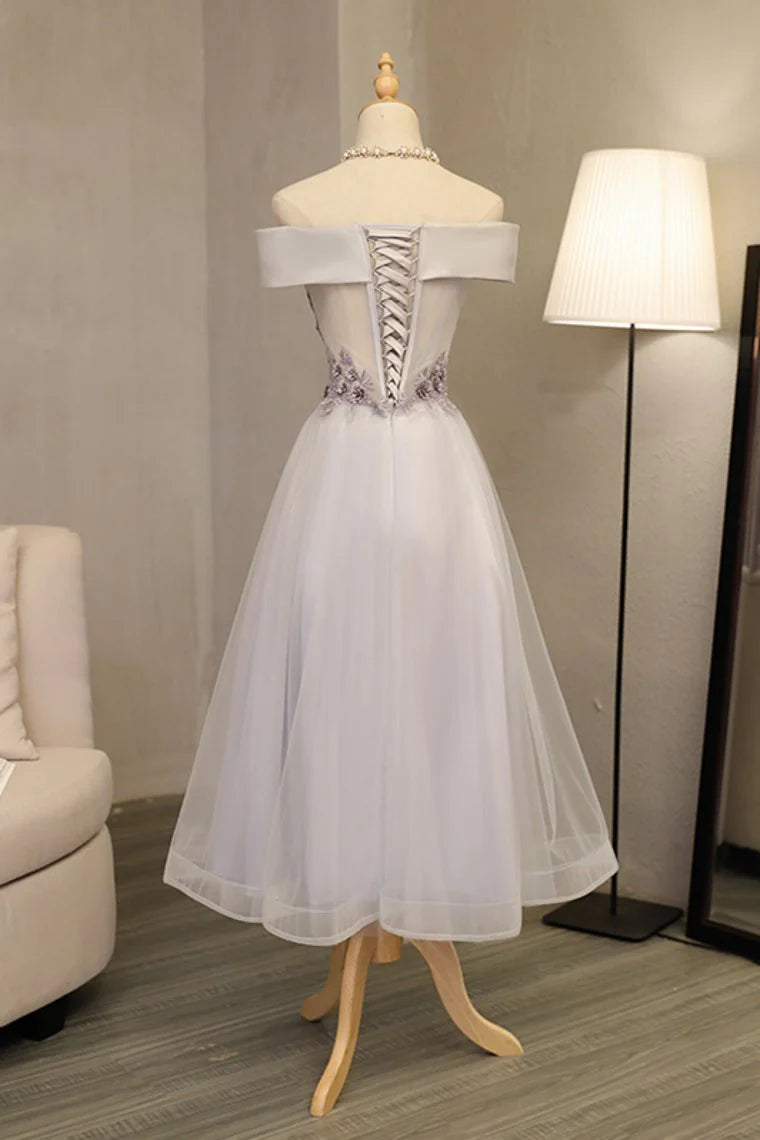 Formal ball dress with a one line boat neck and sheer embellishments featuring stickers and handmade flowers