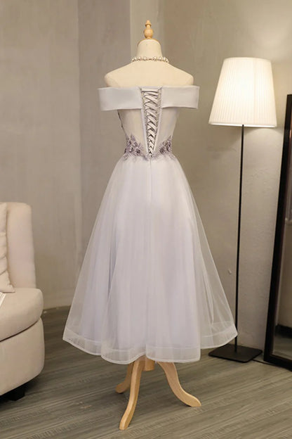 Formal ball dress with a one line boat neck and sheer embellishments featuring stickers and handmade flowers